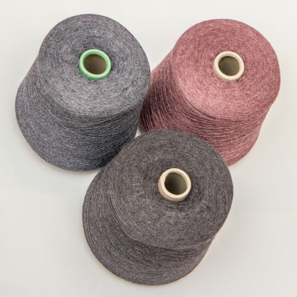 multi-colored bobbins of yarn on a white background. View from above