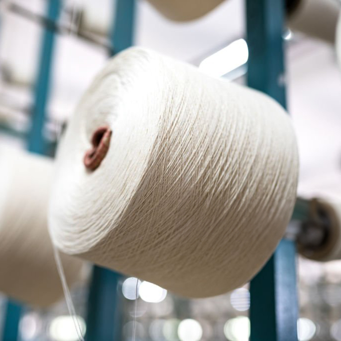 spindle with white yarn in the jean factory