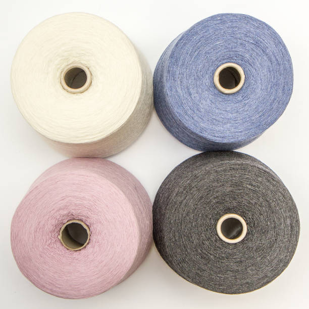 multi-colored bobbins of yarn on a white background. View from above