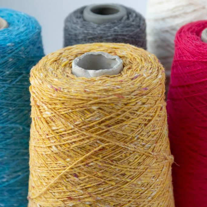 Multi-colored bobbins of wool yarn for hand and machine knitting.